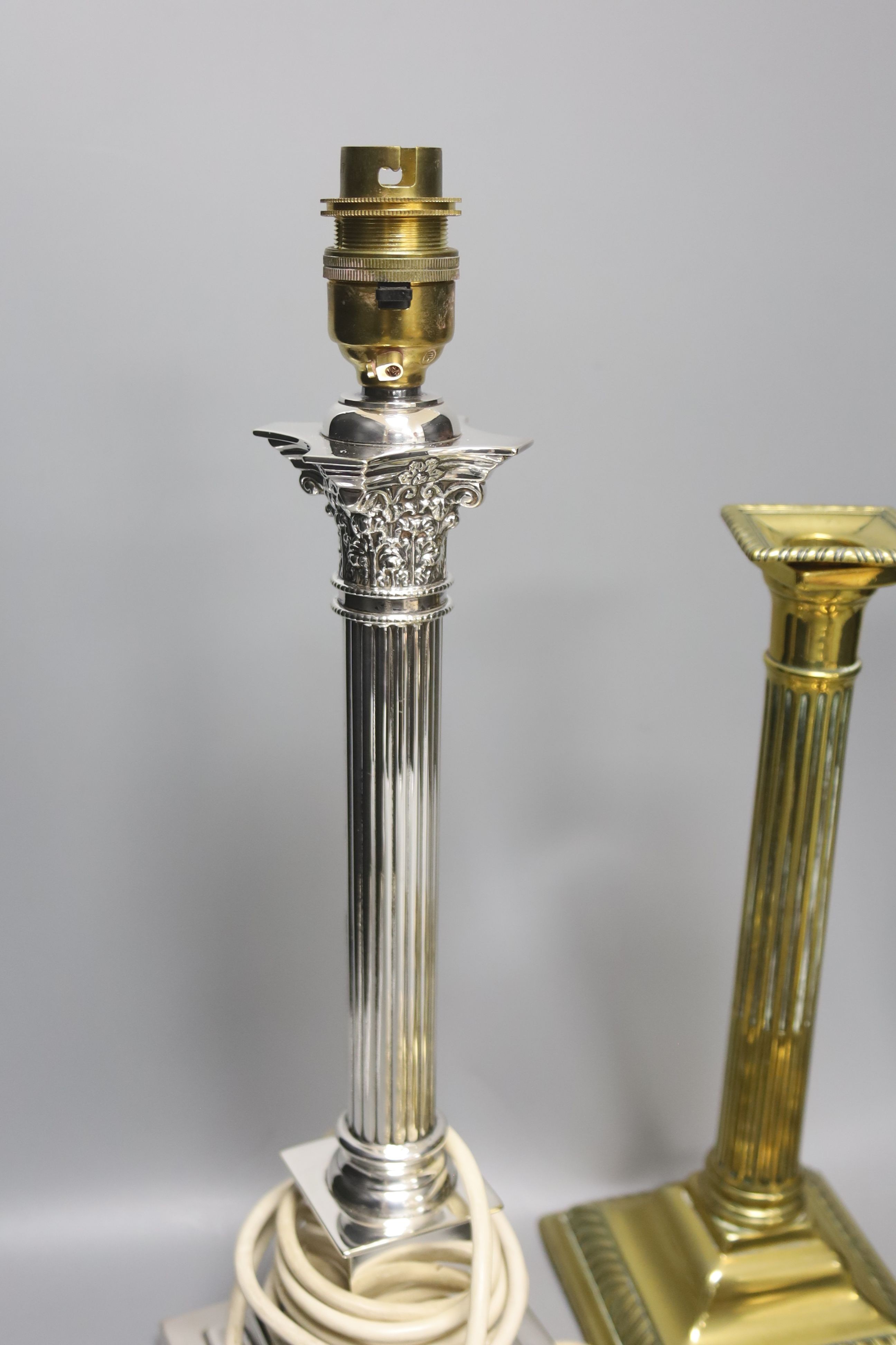 A pair of brass candlesticks, a telescopic candlestick and a silver plated table lamp base